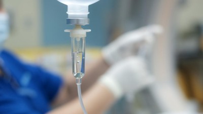 Infusionstropf mit Pflegepersonal im Hintergrund