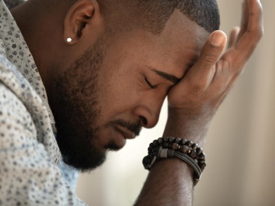 Mann stützt Kopf in die Hand