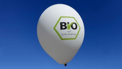 Ein weißer Luftballon vor blauem Hntergrund trägt das Logo des Biosiegels
