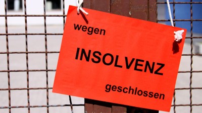 Schild am Zaun mit der Aufschrift "Wegen Insolvenz geschlossen"