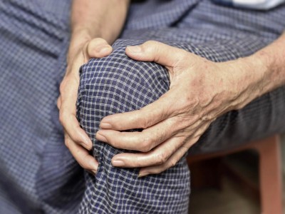 Ältere Person hält sich das Knie