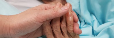 Jüngere Hand hält ältere Hand