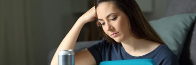 Junge Frau beim Lernen, neben den Unterlagen steht eine Getränkedose