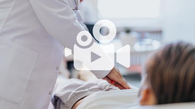 Ärztin tastet Bauch eines Patienten ab