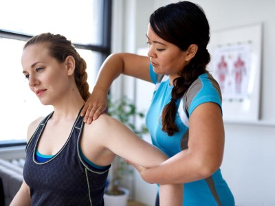 Patientin erhält Physiotherapie am Nacken 