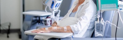Frau mit Kopftuch und Infusion
