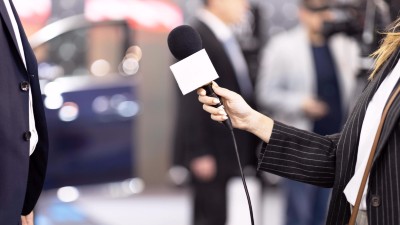 Reporterin mit Mikrophon in der Hand interviewt Person