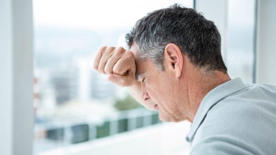 Mann lehnt am Fenster