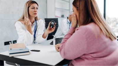 Ärztin spricht mit übergewichtiger Patientin