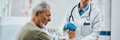 Ärztin untersucht älteren Mann