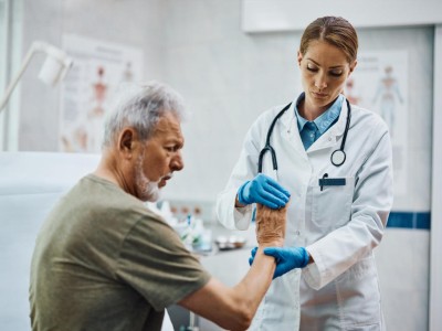 Ärztin untersucht älteren Mann