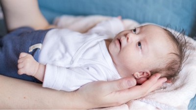 Kleines Mädchen mit Down-Syndrom in den Armen der Mutter
