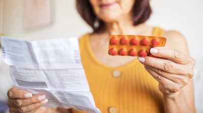 Frau mit Tablettenpackung und Beipackzettel in der Hand