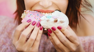 Frau isst reich verzierten Donut