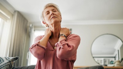 Ältere Frau mit Schmerzen im Nacken
