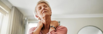 Ältere Frau mit Schmerzen im Nacken