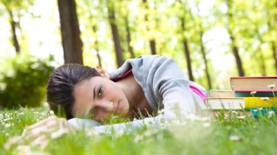 Müde junge Frau liegt im Gras