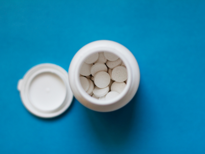 Top view of a bottle of white pills