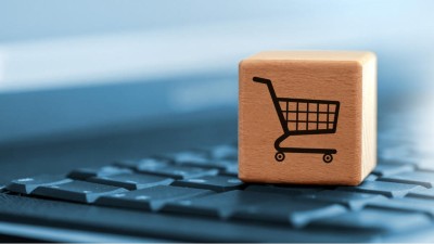 Ein Holzwürfel mit einem Einkaufswagensignet steht auf einer PC-Tastatur