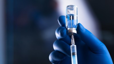 Gloved hand preparing injection