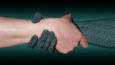 Eine digitale und eine normale Hand greifen ineinander