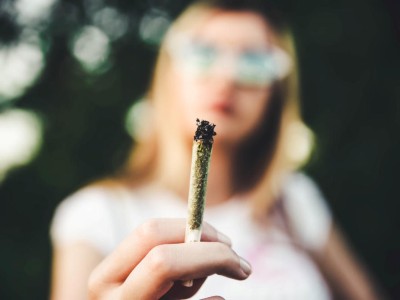 Frau hält Joint in der Hand