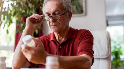 Elderly man looking at medication