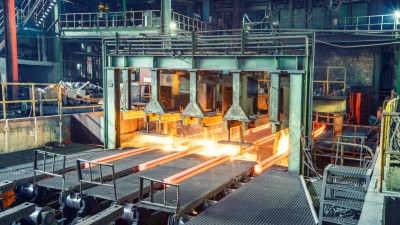 Heißer Stahl auf Förderband im Stahlwerk