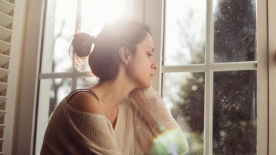 Frau schaut aus dem Fenster
