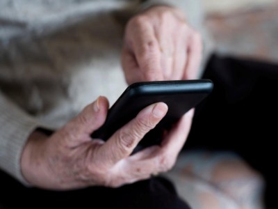 Ältere Person tippt auf Smartphone