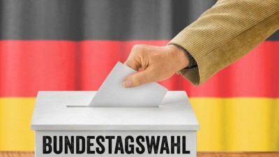 Mann wirft einen Stimmzettel in Wahlurne - Bundestagswahl 2025