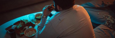 Adipöser Mann isst nachts Burger