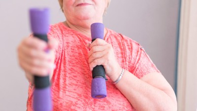 Ältere Frau hält Hanteln in den Händen