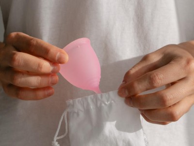 Frau holt Menstruationstasse aus Beutel