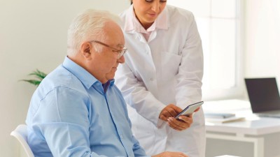 Ärztin erklärt Patienten eine App