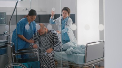 Ärzt überreicht Person Glas mit Tabletten