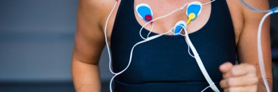 Frau auf einem Laufband mit Elektroden am Oberkörper