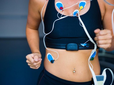 Frau auf einem Laufband mit Elektroden am Oberkörper