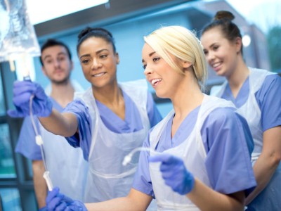 Gruppe von Mitarbeitern bekommen Erklärungen zur Infusion