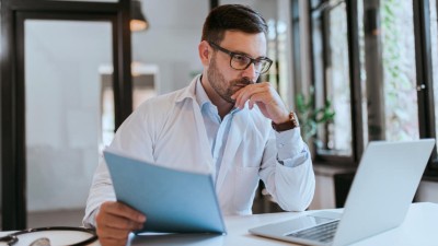 Arzt schaut nachdenklich in den Laptop 