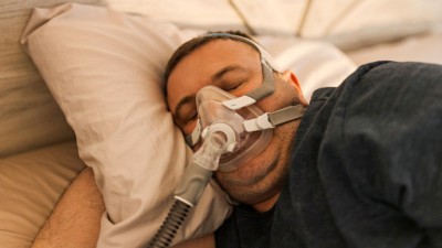 Mann im Bett mit Atemmaske
