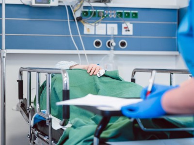 Pflegerin erhebt Vitalparameter bei Patient in Aufwachraum