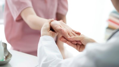 Doctor examining woman's hand