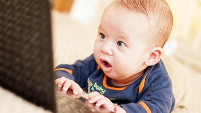 Baby erstaunt, schaut auf Laptop