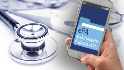 Stetoskopkopf liegt auf Tisch. Daneben eine Hand, die ein Mobildisplay mit Aufschrift ePa hält