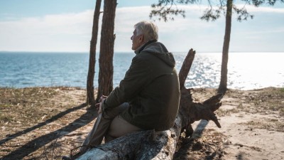 Person sitzt am Wasser