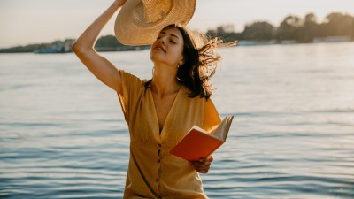 Frau im gelben Kleid sitzt im Wasser