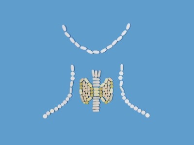 Image is a photograph of pills in the shape of the thyroid gland on a blue background