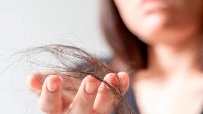 Frau hält Haare in der Hand