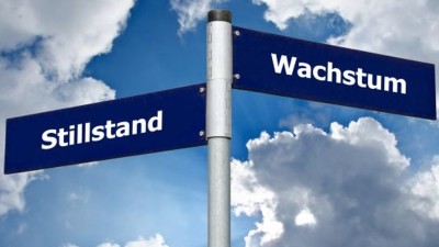 Zwei Wegweiser mit den Aufschriften Stillstand und Wachstum.